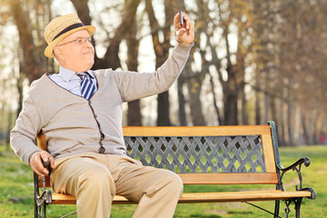 Poster - Senior adult taking a selfie in park