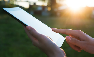 Close up of a womman using mobile tablet pc outdoor Writting