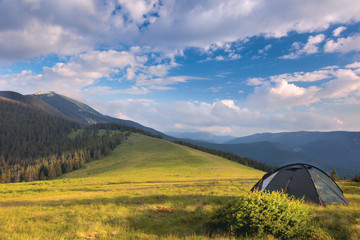 Wall Mural - camping tent in the mountains. summer, blue sky, clouds and high