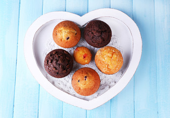 Canvas Print - Tasty muffins on tray, on color wooden background