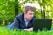© kosmos111 - businessman intently working on a laptop on the grass