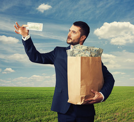 Poster - pensive man looking at one hundred dollars