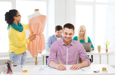 Canvas Print - smiling fashion designers working in office