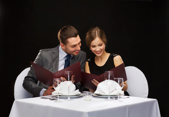 Canvas Print - smiling couple with menus at restaurant