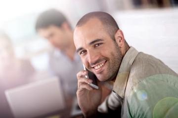 Wall Mural - Cheerful salesman talking on the phone