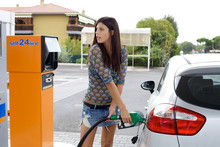 Happy Woman Pumping Gas In Car