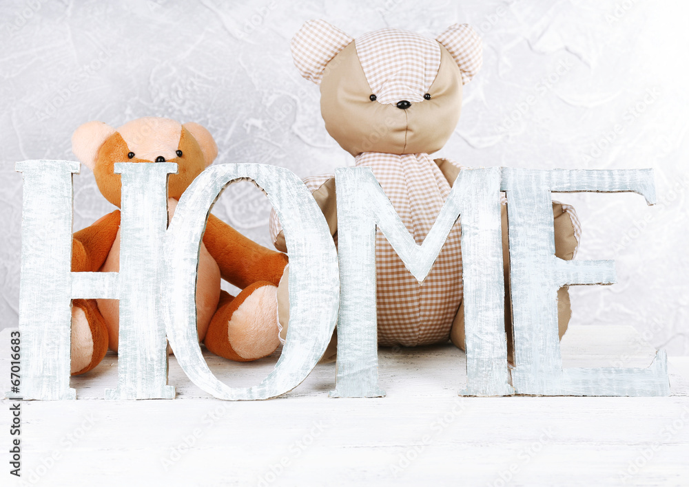 Decorative letters forming word HOME with teddy bear