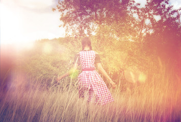 Wall Mural - Young woman in dirndl walking alone in the field