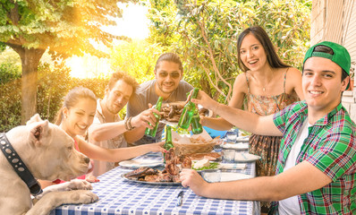 Group of happy friends eating and toasting at garden barbecue