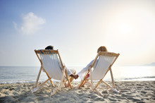 Romantic Couple On Deckchair Relaxing On The Beach