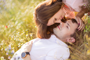 Portrait of a young couple posing in summer in the field