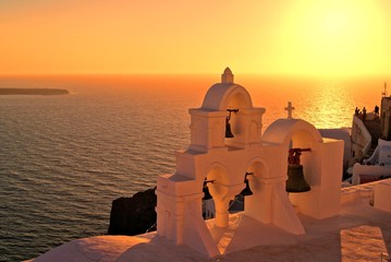 Wall Mural - Church bells of Santorini Greece overlooking the sea at sunset