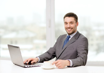 Canvas Print - smiling businessman with laptop and coffee