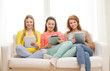 © Syda Productions - three smiling teenage girls with tablet pc at home