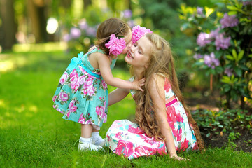 Wall Mural - portrait of two sisters in a park in spring