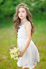 Wall Mural - portrait of a beautiful little girl with chamomile