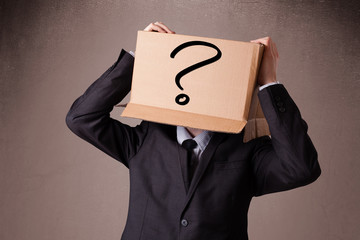 Businessman gesturing with a cardboard box on his head with ques