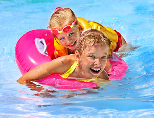 Children in life jacket at swimming pool.