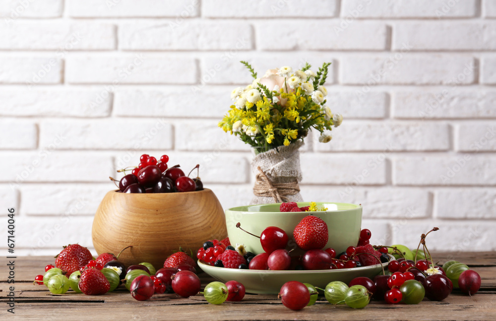 Still life with berries and flowers on white wall background