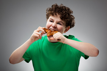 Wall Mural - Boy eating roasted chicken leg