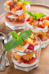 fruit dessert with whipped cream, mint and granola, top view