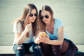 two beautiful young women using smart phone