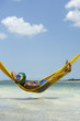 © lazyllama - Brazilian Man Relaxing in Beach Hammock Over Sea