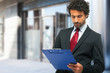 © Minerva Studio - Businessman holding a clipboard