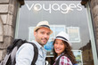 © Production Perig - Young happy couple in front of travel agency