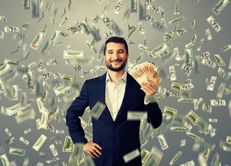 Canvas Print - happy businessman standing under money rain