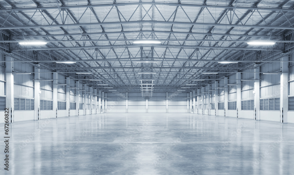 Concrete floor inside industrial building. Use as large factory, warehouse, storehouse, hangar or plant. Modern interior with metal wall and steel structure with empty space for industry background. - obrazy, fototapety, plakaty 
