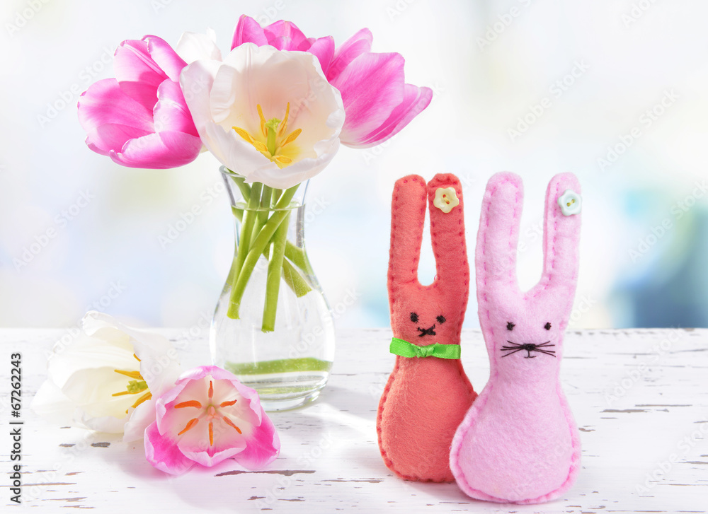 Beautiful tulips in bucket in vase on table on light background