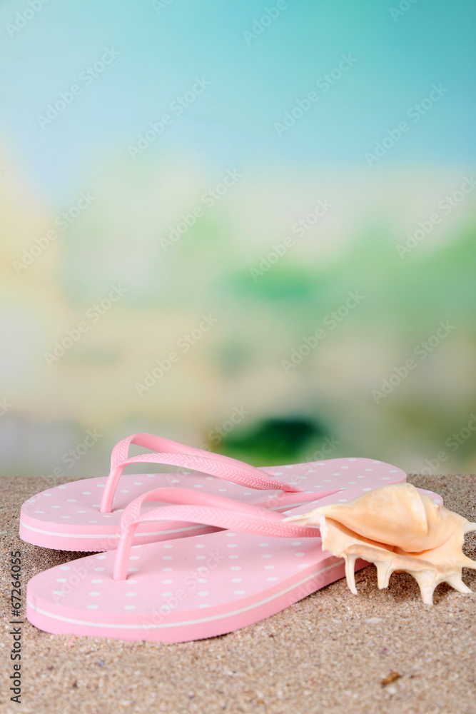 Color flip-flops on sand, on nature background