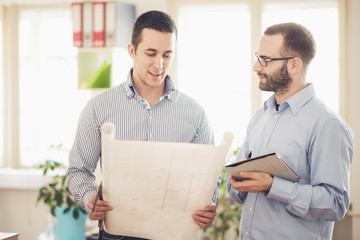 Two Architects working at blue print