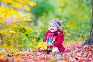 Wall Mural - Little funny girl having fun in an autumn sunny park