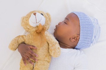 adorable baby boy sleeping peacefully with teddy
