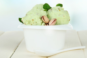 Wall Mural - Tasty ice cream scoops in bowl, on wooden table