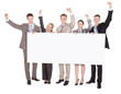 © Andrey Popov - Business People With Arms Raised Holding Blank Billboard