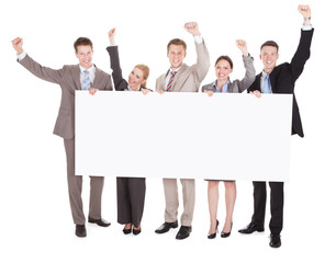 business people with arms raised holding blank billboard
