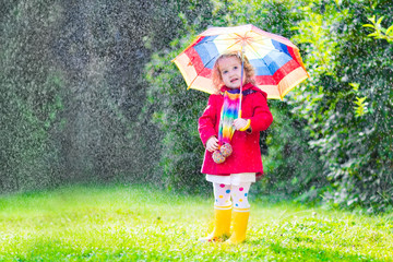 Wall Mural - Little funny girl playing in the rain