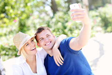 Wall Mural - Young couple taking a picture of themselves at the beach