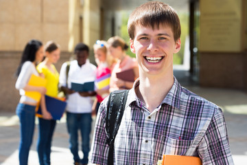 Wall Mural - Portrait of college boy holding books