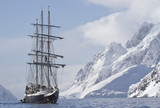 Fototapeta  - tourist ship sailing summer day on a background of mountain peak