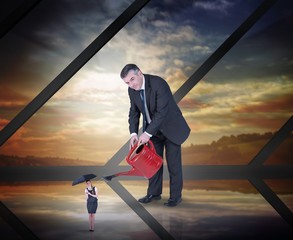 Poster - Composite image of mature businessman watering tiny businesswoma