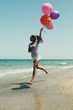© dubova - beautiful woman with colorful balloons on seaside