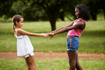 Children playing ring around the rosie in park