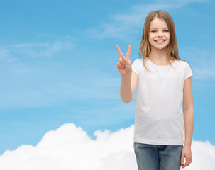 Canvas Print - little girl in white t-shirt showing peace gesture