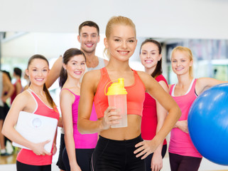 Canvas Print - smiling sporty woman with protein shake bottle