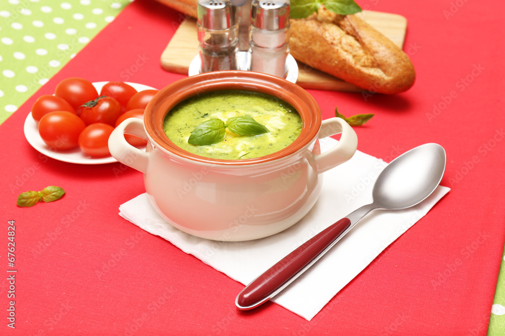 Tasty soup in saucepan on tablecloth, close up