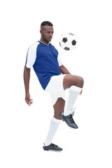 Football player in blue jersey controlling ball